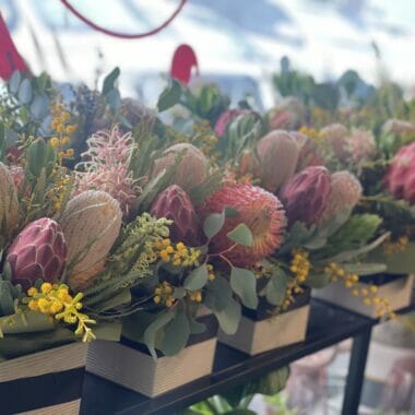 Elegant wildflower box arrangement featuring a vibrant mix of Australian native flowers including Protea, Banksia, and Eucalyptus in a stylish, posy box