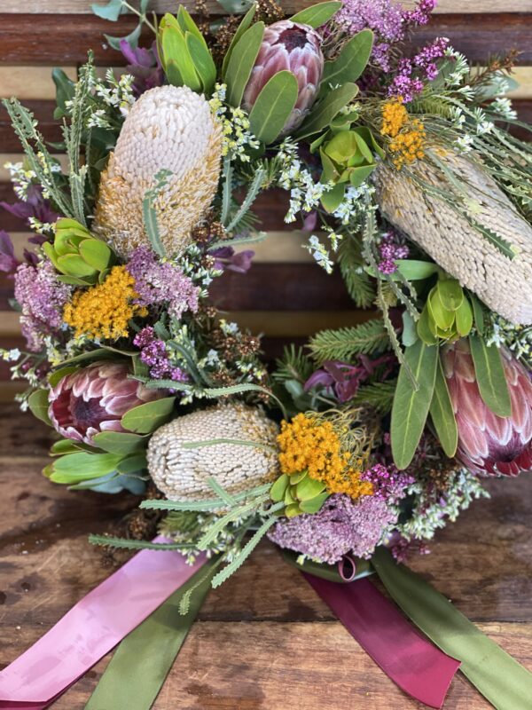 Beautiful wildflower wreath featuring an array of Australian native blooms such as Banksia, Protea, and Eucalyptus, arranged in a natural, rustic design perfect for memorial service