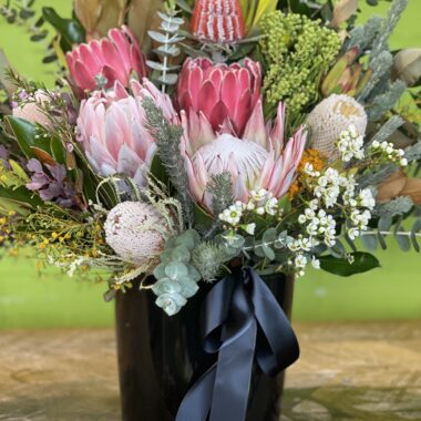 Elegant corporate wildflower arrangement featuring Australian native blooms such as Protea, Banksia, and other wildflowers in a modern vase, designed to enhance office spaces with natural beauty